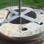 To confer rigidity additional to that inherent in the heavy pillars, each pillar was built around and secured to a central steel rod set into the concrete foundation and with a large nut screwed down at the top.